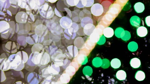 Multicolored Christmas lights sparkle on the Christmas tree. The magic of Christmas and New Year.