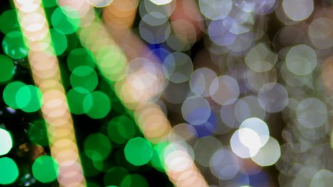 Abstract background. Multicolored Christmas lights sparkle on the Christmas tree. The magic of Christmas and New Year.