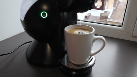 Coffee machine finishes make cup of coffee. Drops of espresso from the coffeemachine are falling into the mug