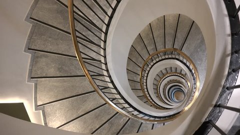 4K Beautiful spiral staircase in interior hall of house, stair circular rotation, handheld camera