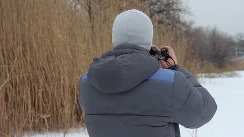 Photographer takes pictures on the pond in winter.
