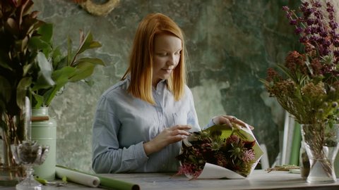 woman putting together an arrangement of flowers