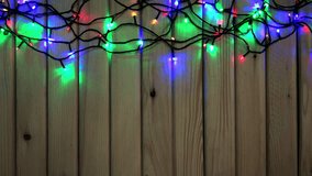 LED Colorful Christmas Lights on Wooden Background with place for Your Text. 4K Ultra HD 3840x2160 Video Clip