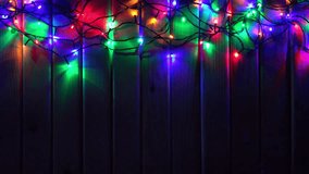 LED Colorful Christmas Lights on Wooden Background with place for Your Text. 4K Ultra HD 3840x2160 Video Clip