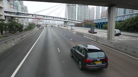 HONG KONG - APRIL 01, 2015: Ride along highway, pass pedestrian skyway, three different elevated walkway above roadway. Pedestrian overpasses, connecting Olympic MTR station with Olympian City