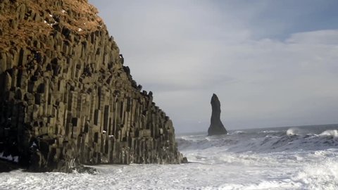 Reynisdranger, basalt sea stacks with the wave and black sand beach near the small village Vik i Myrdal in the south of Iceland