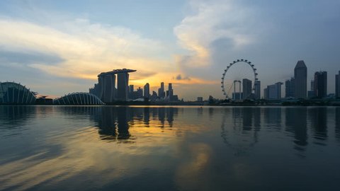 Beautiful Time lapse of Day to Night of Singapore skyline with reflection. 4K UHD. Zoom In Camera Motion.