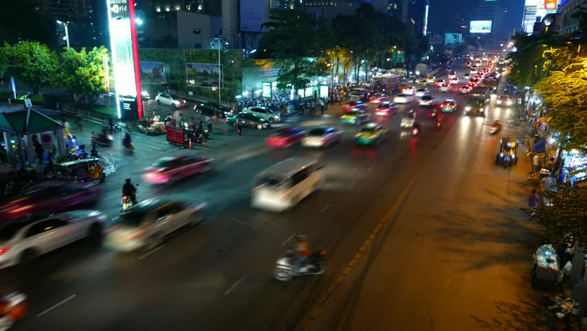 Traffic gathering to large congestion, wide night road perspective view, time lapse shot. Ratchadamri road and exit alley from Central World shopping complex parking area, Pathum Wan district, Bangkok