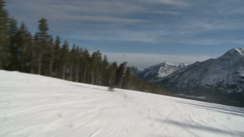 Camera follow shot of snowboarder