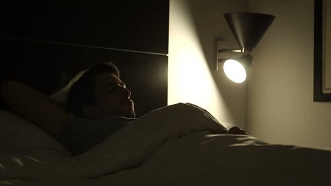 Person turns on the light in the middle of the night suffering from insomnia