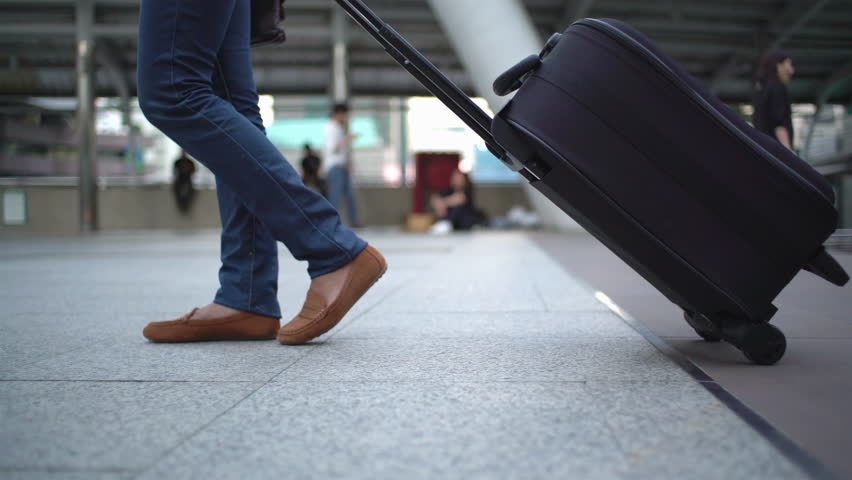 traveler dragged baggage walking on the way at  downtown of Bangkok. Only legs :Gimbal shot.