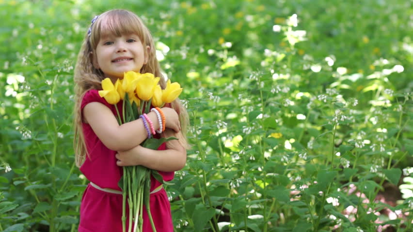 Girl hugging a bouquet of yellow tulips