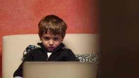 Child watching cartoons in front of computer screen