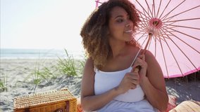 Portrait of plus size Ethnic African American female with a parasol at the beach in the sand dunes RED DRAGON