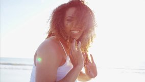Portrait of laughing voluptuous Ethnic African American female relaxed and carefree in a white dress by the ocean at sunset RED DRAGON