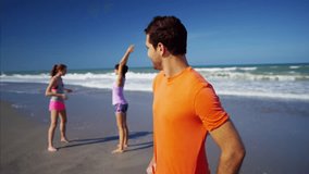Portrait of young happy Caucasian American male enjoying exercise on the beach RED DRAGON