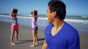 Portrait of young happy Latin American male enjoying exercise on the beach RED DRAGON