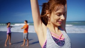 Portrait of young happy Caucasian American female enjoying exercise on the beach RED DRAGON