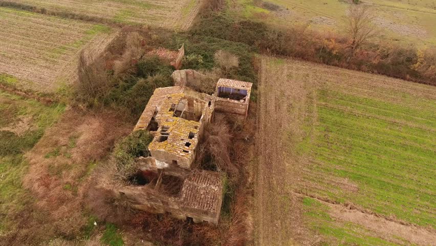 Aerial shot, old ruined abandoned house in the middle of the field, in Tuscany, Italy, shot with drone