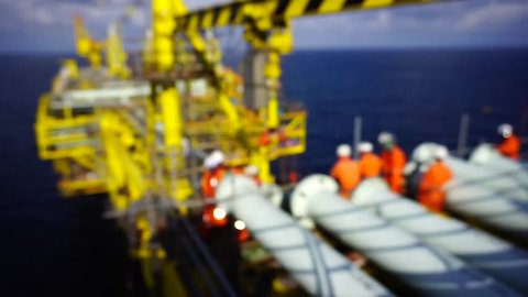 Motion blur. Working overboard. Working at height. Offshore workers perform lifting activities using overhead crane on top of oil and gas rig platform in the middle of South China Sea.