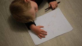 video kid drawing lying on the floor