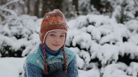 A child playing in the park in the snow. Portrait of a baby boy outside in winter. Boy playing in the snow, throws a snowball at the camera. 