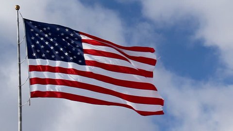 American Flag Waving against Blue Sky. American flag waving against blue sky and white clouds. Filmed at 60 fps and slowed down to 30 fps. Video Stok
