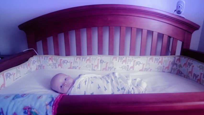 Beautiful baby lying awake in crib