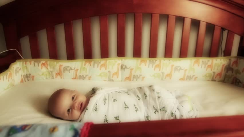 Beautiful baby lying awake in crib