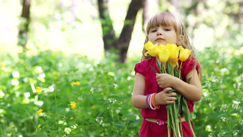 Little girl hugging a bouquet of yellow tulips
