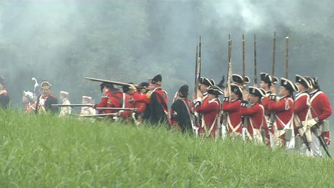 NEW YORK - MARCH 2016 - large-scale, epic American Revolutionary War anniversary reenactment -- in the middle of battle. British Redcoat Army infantry volleys and fires in line of battle.