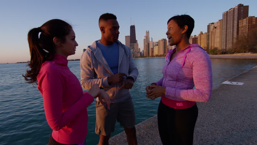 Multi Ethnic male and females resting together in Chicago relaxed after fitness exercise and sport recreation RED DRAGON