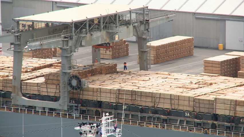 Packets of timber being loaded on a ship for export. Timelapse