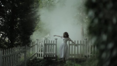 VIRGINIA - SUMMER 2016 - Reenactment, Recreation -- Ghostly, undead woman in smoky garden / graveyard.  Paranormal, poltergeist.  Mystery woman with pale pallor, 19th century clothing in misty smoke