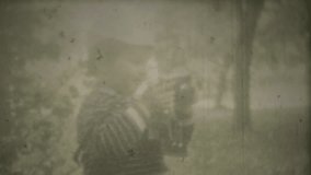 Little boy photographing his mother, mom posing with hand puppet. Screenshot of 8mm retro camera. Family chronicle.