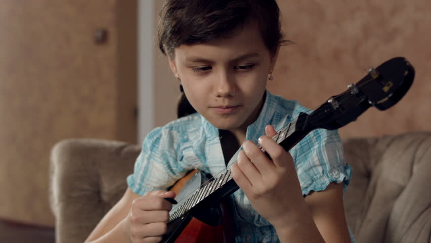 Girl learning to play mandolin ( dombra)
