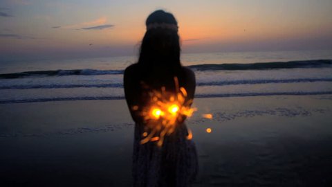 Silhouette of slim Asian Indian female enjoying 4th July party with sparklers on the beach at sunset स्टॉक व्हिडिओ