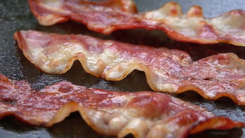 Close-up of a slice of bacon fried on a hot grill