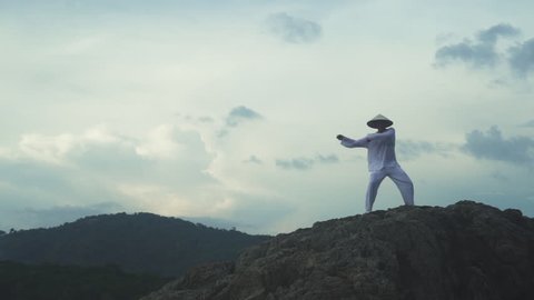 Man in white uniform training martial arts forms alone for defense training and its health benefits