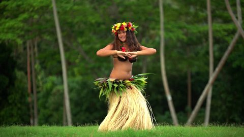 Barefoot Tahitian female in hula skirt and flower headdress performing a graceful traditional dance at celebration ceremony French Polynesia South, Pacific,