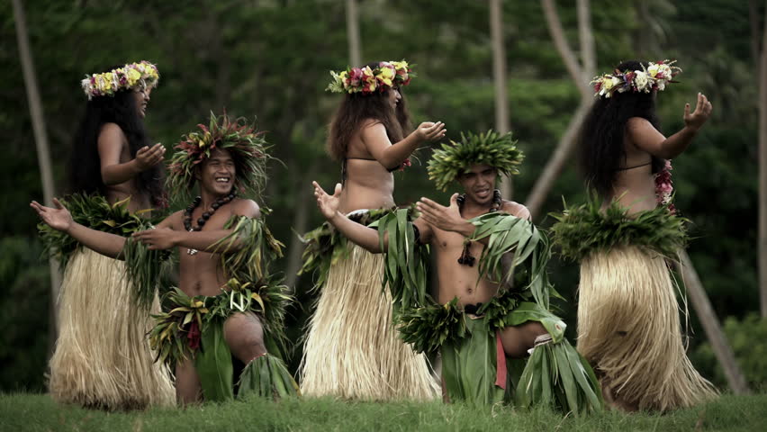 girls in grass skirts and flower headdress dancing hula style while enterta...