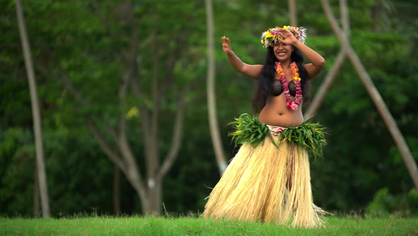 grass skirt and flower headdress dancing hula style while entertaining bare...