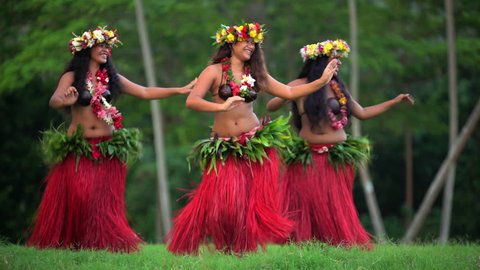 Group of beautiful young synchronized Polynesian females dancers entertaining in traditional costume barefoot outdoor French Polynesia South Pacific