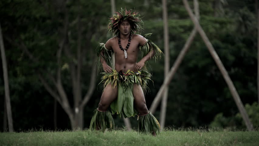 Young Tahitian male performing war dance style hula dance outdoors barefoot in traditional costume Tahiti French Polynesia South Pacific