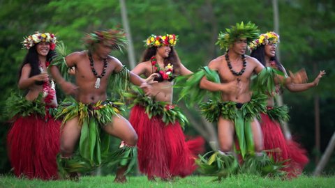 Group of beautiful young synchronized Polynesian male and female dancers entertaining in traditional costume barefoot outdoor French Polynesia South Pacific