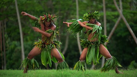 Young Tahitian males performing war dance style hula dance outdoors barefoot in traditional costume Tahiti French Polynesia South Pacific