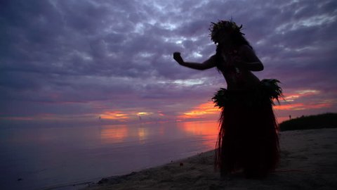 Young Polynesian female Tahitian hula dancer performing at sunset on ocean beach barefoot in traditional costume Tahiti French Polynesia South Pacific