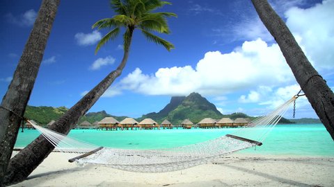 Beach palm trees hammock Overwater luxury Bungalows in tropical Aquamarine lagoon a Tahitian vacation resort of Bora Bora South Pacific
