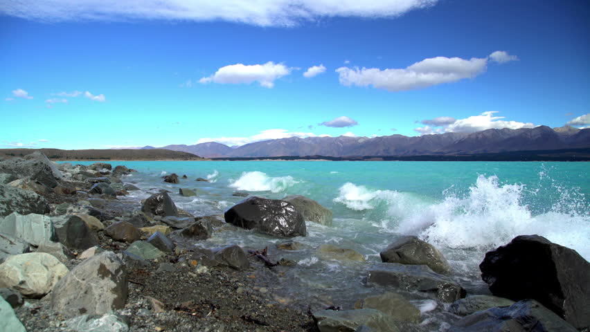 Natural beauty of turquoise water and waves over rocks on Lake Tekapo Mackenzie Basin South Island New Zealand