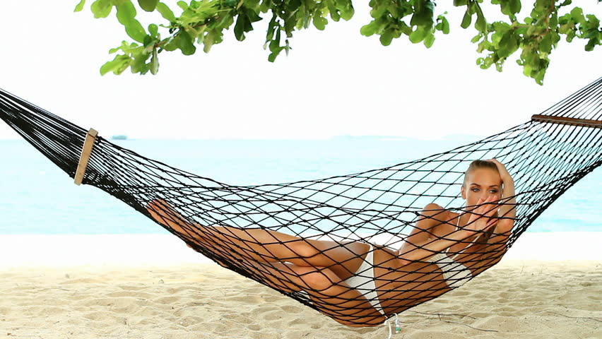 Beautiful woman full of vitality reclining suntanning in a hammock on a tropical